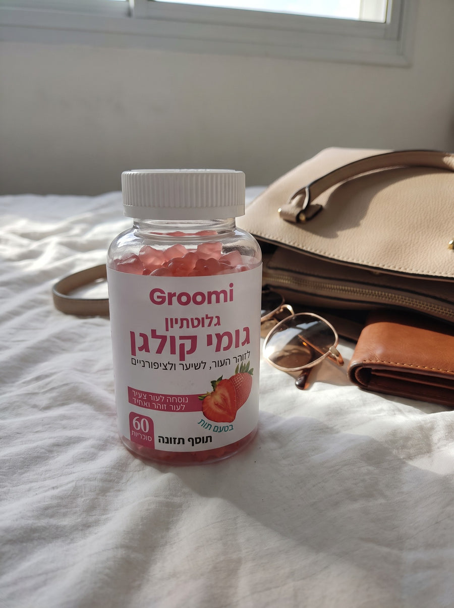 בקבוק גומי קולגן של Groomi על המיטה ליד תיק יד