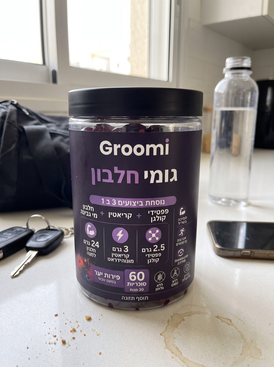 צנצנת גומי חלבון של Groomi על השיש במטבח, ליד תיק אימון ומפתחות