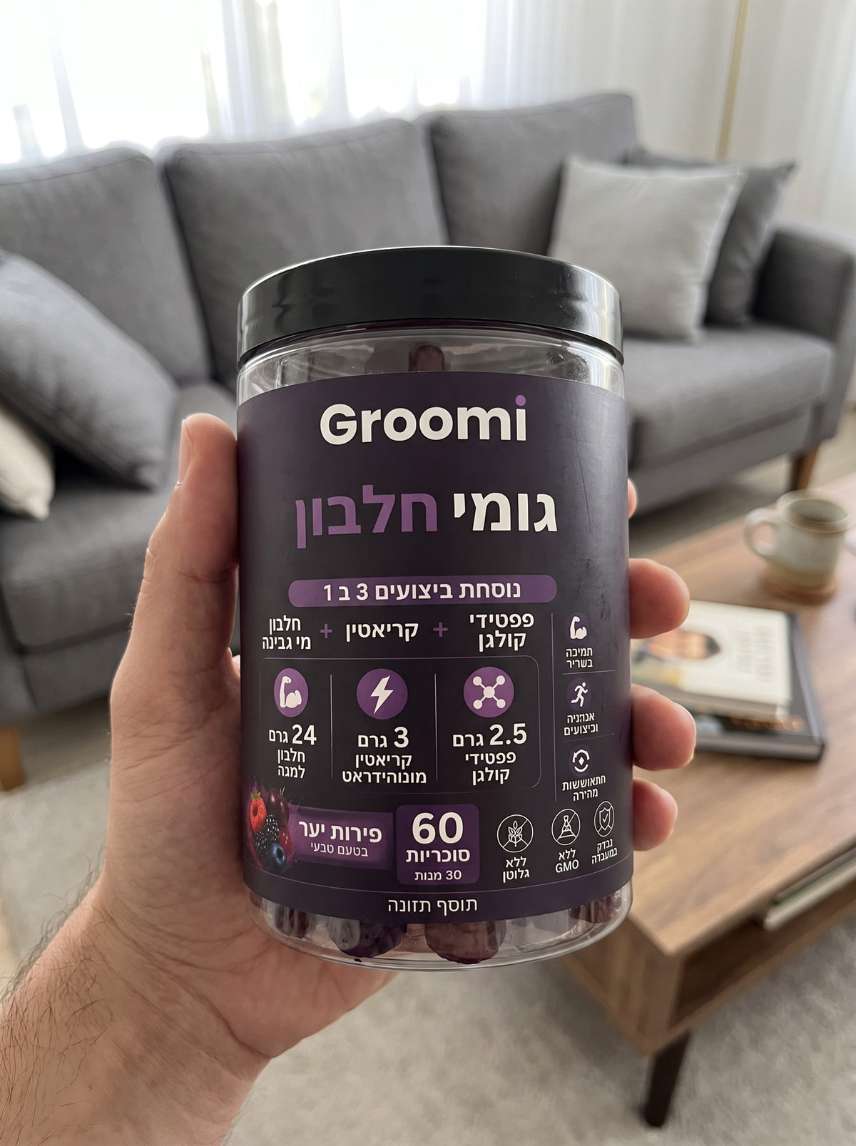 יד מחזיקה צנצנת גומי חלבון של Groomi בסלון