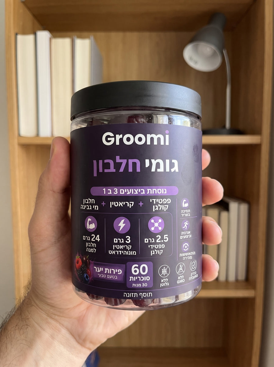 יד מחזיקה צנצנת גומי חלבון של Groomi בחדר העבודה