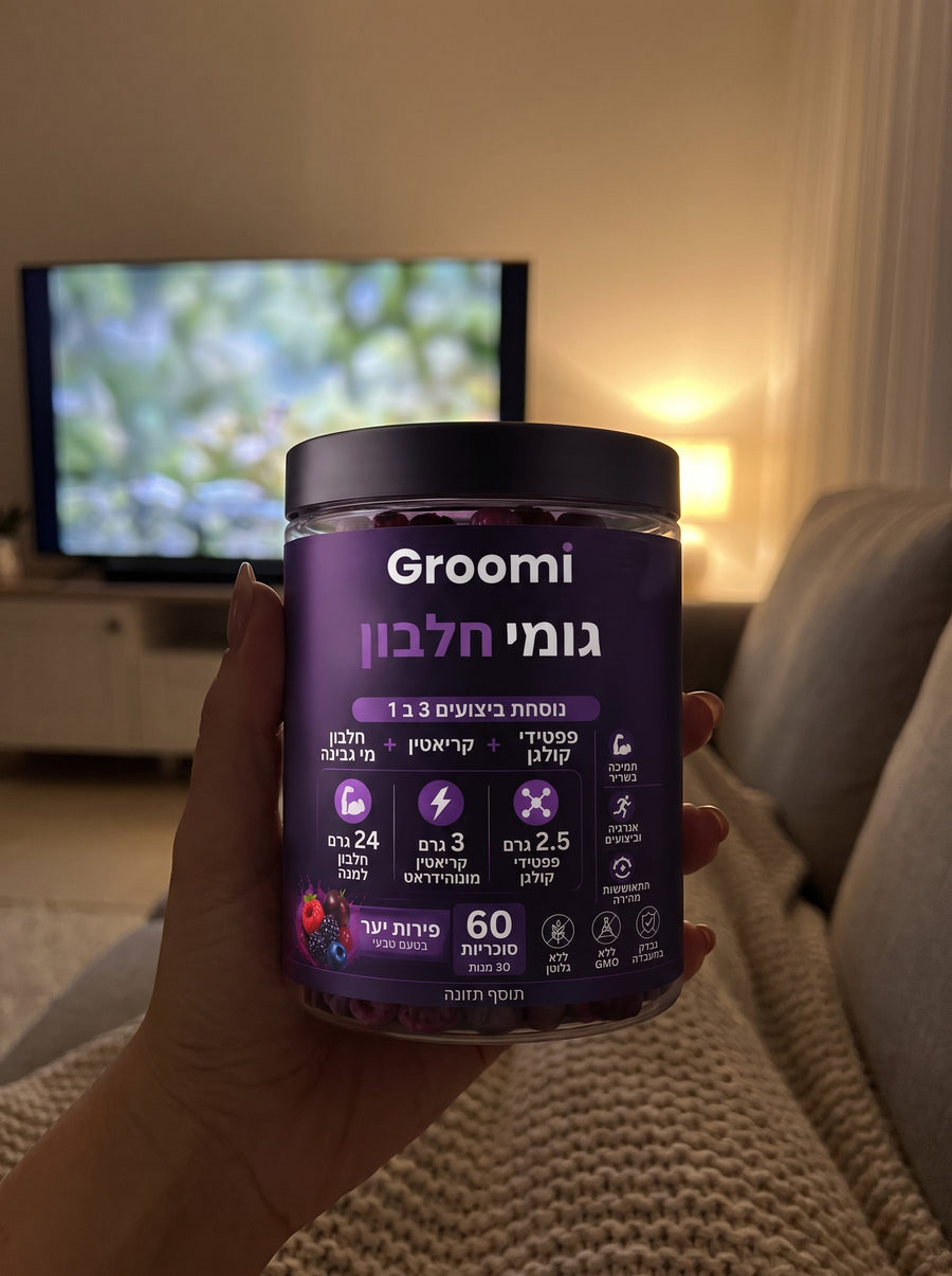 יד מחזיקה צנצנת גומי חלבון של Groomi מול הטלוויזיה
